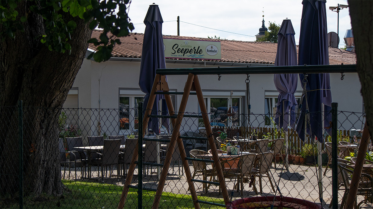 Lindow (Mark)’ta 52.9719000, 12.9828333 yakınındaki Gudelacksee kıyısında Seeperle restoranı; teras, oyun alanı ve göle yakın mola imkanı.